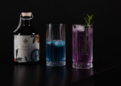 Munakra Gin – HANDCRAFTED VIENNA DRY GIN, eine Wacholderspirituose mit außergewöhnlicher, ausbalancierter Aromatik und floralen Zitrusnoten. Geheimnisvoll. Natürlich. Handgemacht. Natürlicher Farbwechsel auf Grudn mystischer Blume von blau auf vio. Florale Zitrusnoten